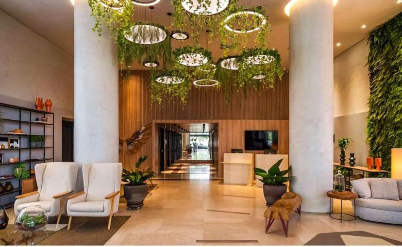 a lobby with white chairs and a large chandelier at Itaim Bibi - The Capital Flat - Apto 1211 in São Paulo
