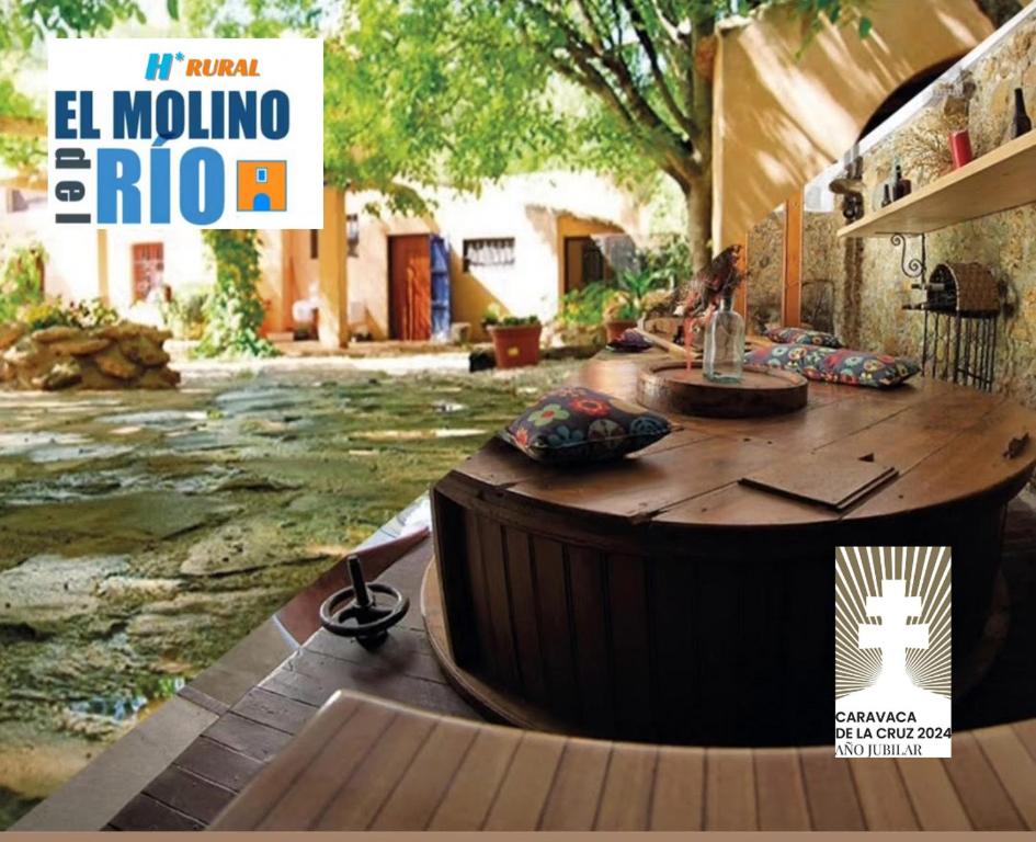 una portada de revista con una gran mesa de madera en un patio en H Rural Molino del Rio Argos en Benablón
