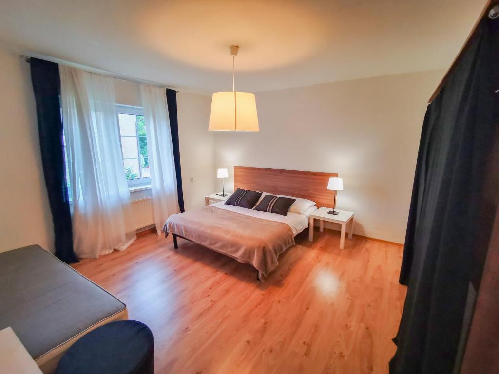 ein Schlafzimmer mit einem Bett und einem Sofa in der Unterkunft Apartamenty Bystrzycka 63 in Polanica-Zdrój