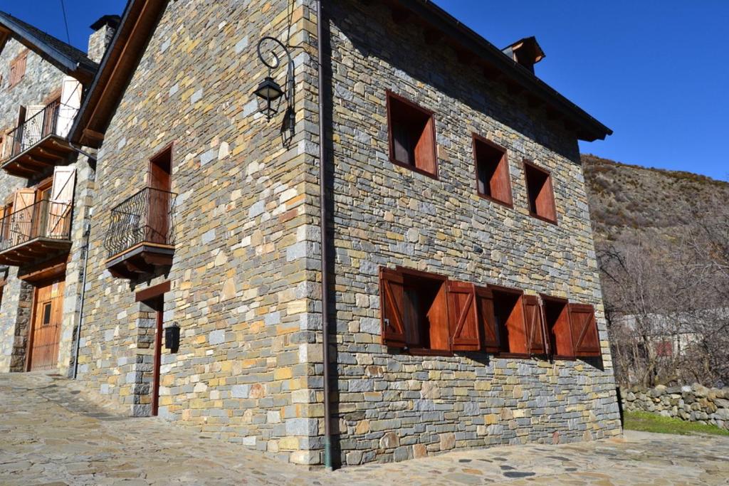 a large brick building with open windows on it at NRY ESTANCES I SERVEIS EL TARTER 2 in Erill la Vall