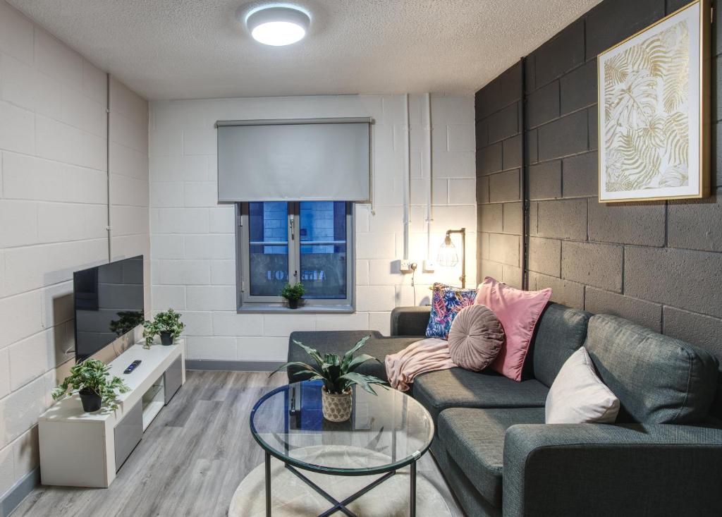 a living room with a couch and a table at #10 Phoenix Court By DerBnB, Industrial Chic 1 Bedroom Apartment, Wi-Fi, Netflix & Within Walking Distance Of The City Centre in Sheffield