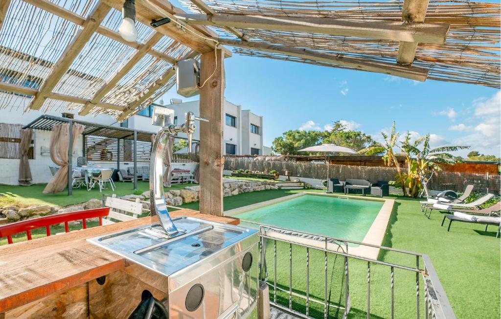 un patio al aire libre con piscina y sombrilla en Awesome Home In Valldemar With Wi-fi, en Gornal