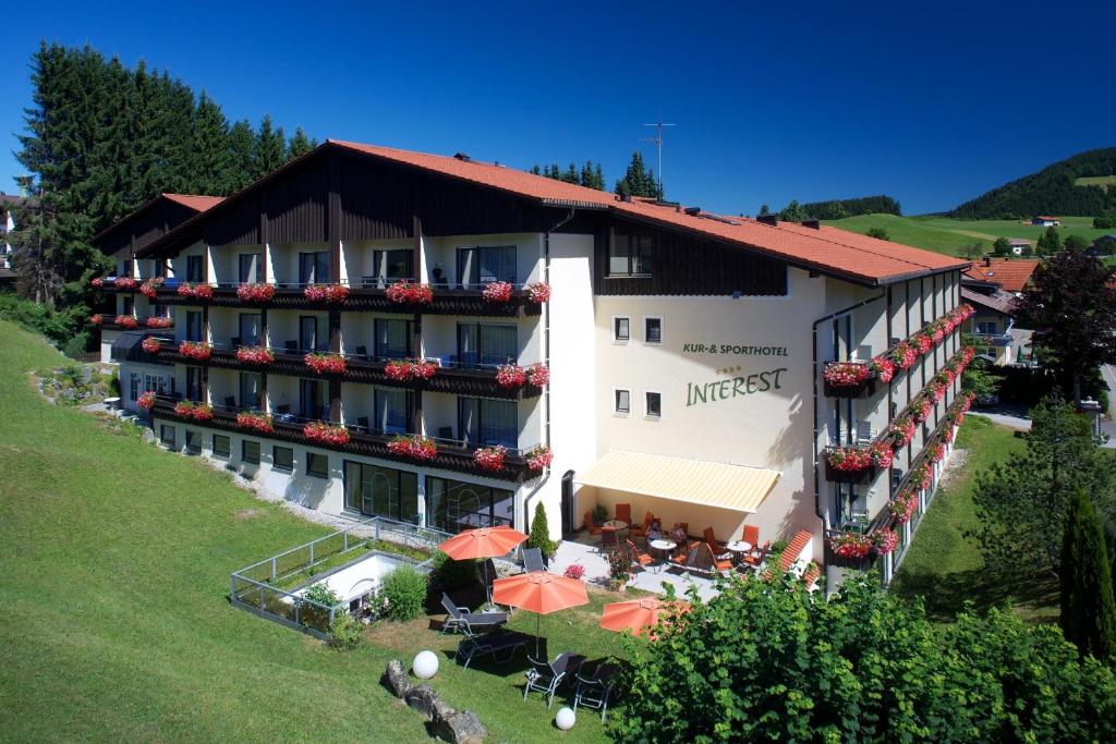 eine Luftansicht eines Hotels mit Tischen und Sonnenschirmen in der Unterkunft Interest Vitalhotel in Oberstaufen