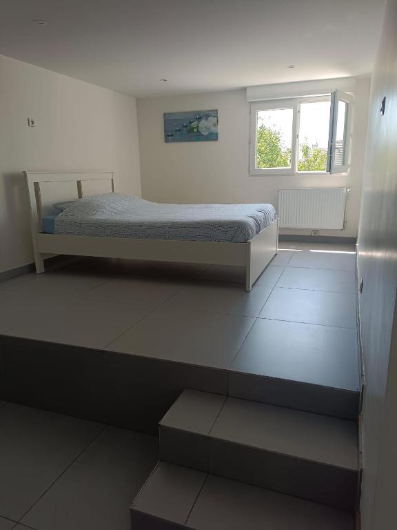 a bedroom with a bed and a window at 2Appartement dans un pavillon ac vue sur le jardin in Argenteuil