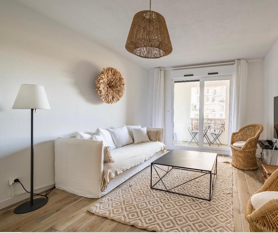 uma sala de estar com um sofá branco e uma mesa em Face à l'Arbre Blanc, Neuf Clim Parking em Montpellier