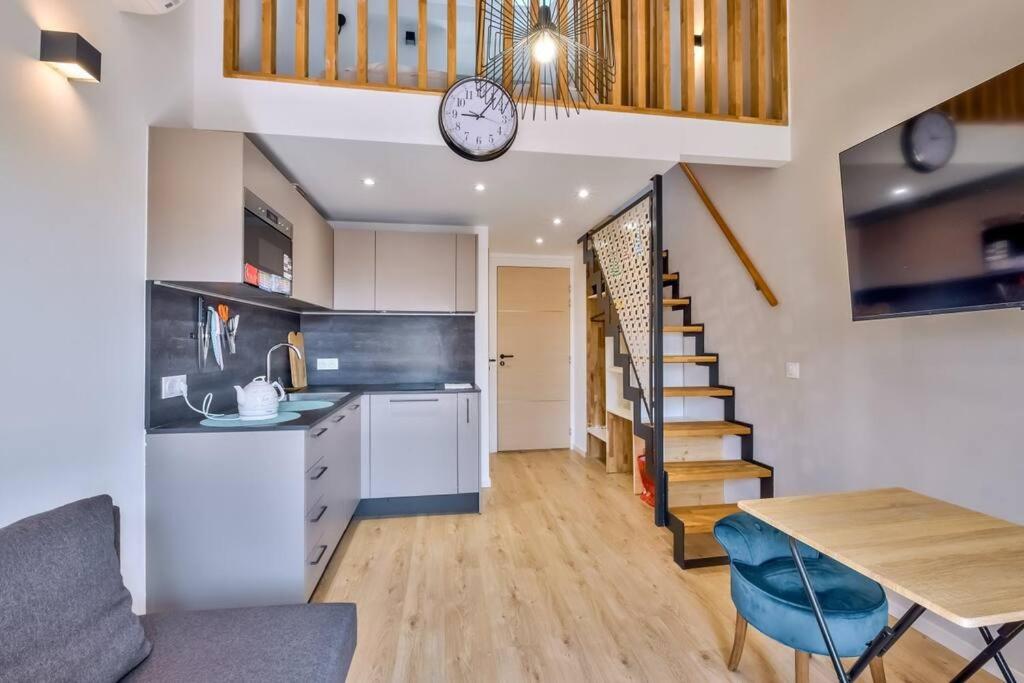 a kitchen and dining room with a table and a clock at Magnifique appartement à proximité de la plage in Nice