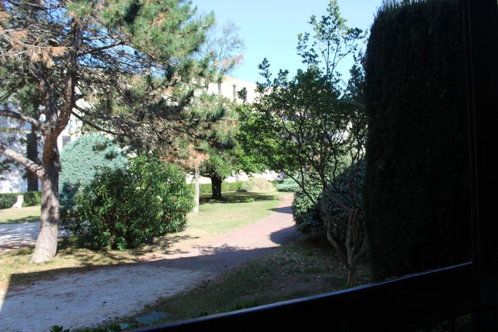 - une vue sur un chemin arboré et un bâtiment dans l'établissement Appartement T2 avec terrasse et parking à 400 m du Port - 4RS207, à Saint Cyprien Plage
