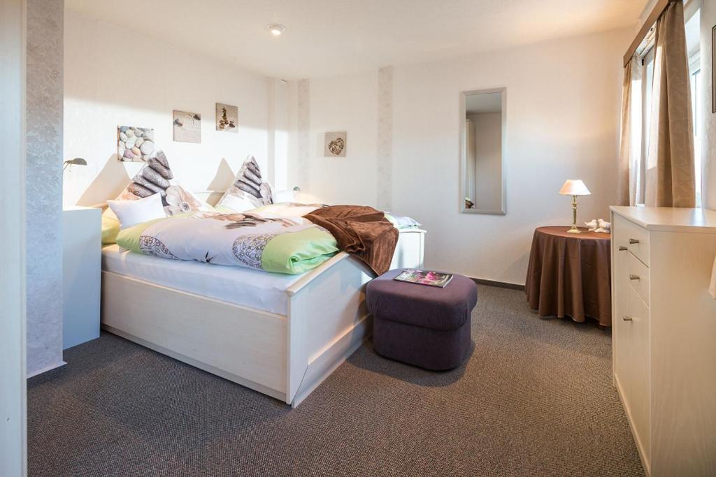 Un dormitorio con una cama y una maleta. en Haus Naase App 3 en Norderney