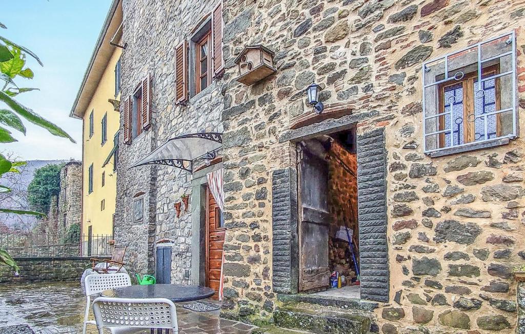 um edifício de pedra com uma mesa em frente em 2 Bedroom Pet Friendly Home In Borgo A Mozzano em Borgo a Mozzano