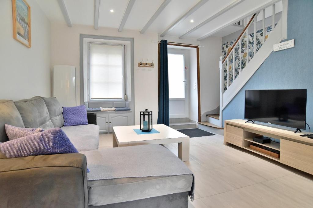un soggiorno con divano e TV a schermo piatto di Maison Castine - Maison pour 6 a Saint-Cast-le-Guildo
