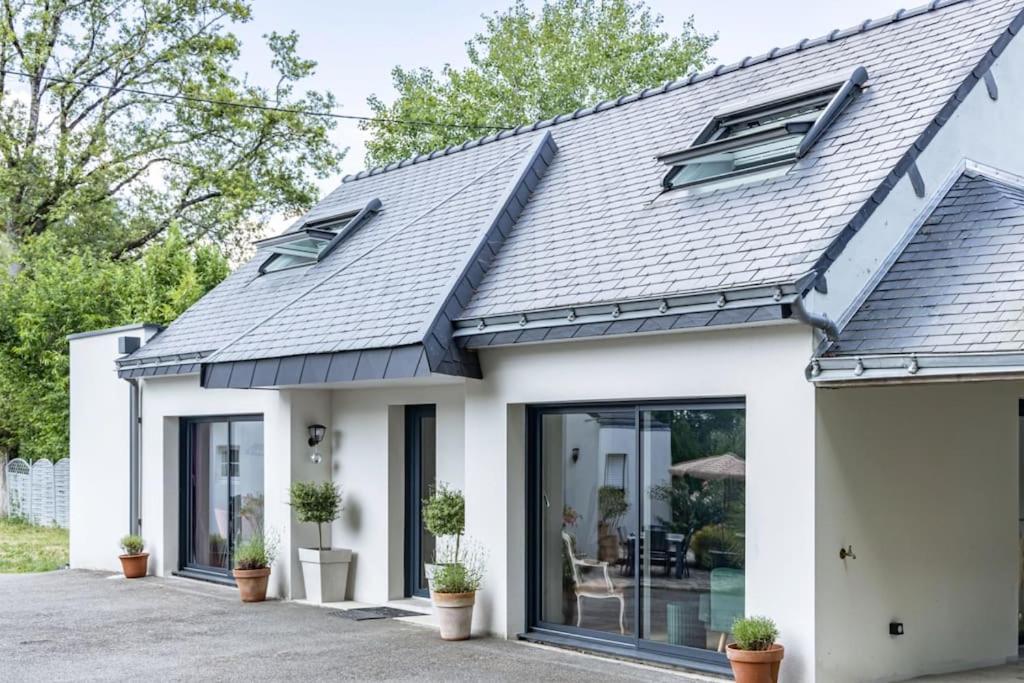 une maison avec un toit en métal dans l'établissement Propriété au vert idéal pour déplacements pro et voyages famille, à Treillières