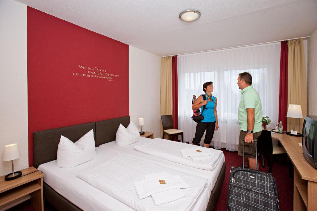 un hombre y una mujer de pie en una habitación de hotel en Aparthotel Oberhof en Oberhof