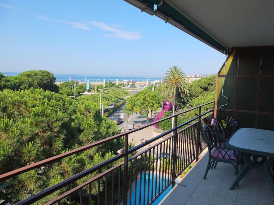 balcón con mesa, sillas y vistas al océano en Apartment in front of the beach, en Castelldefels