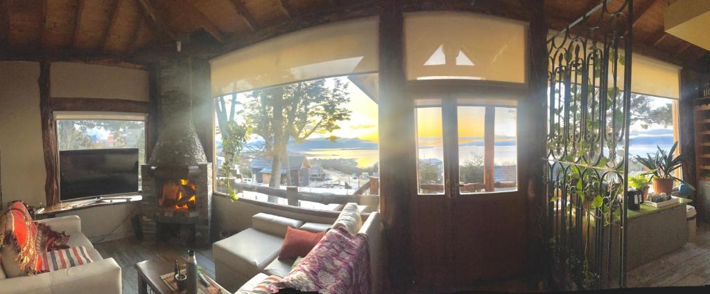a living room with a couch and a large window at Morada del Leñador in Ushuaia