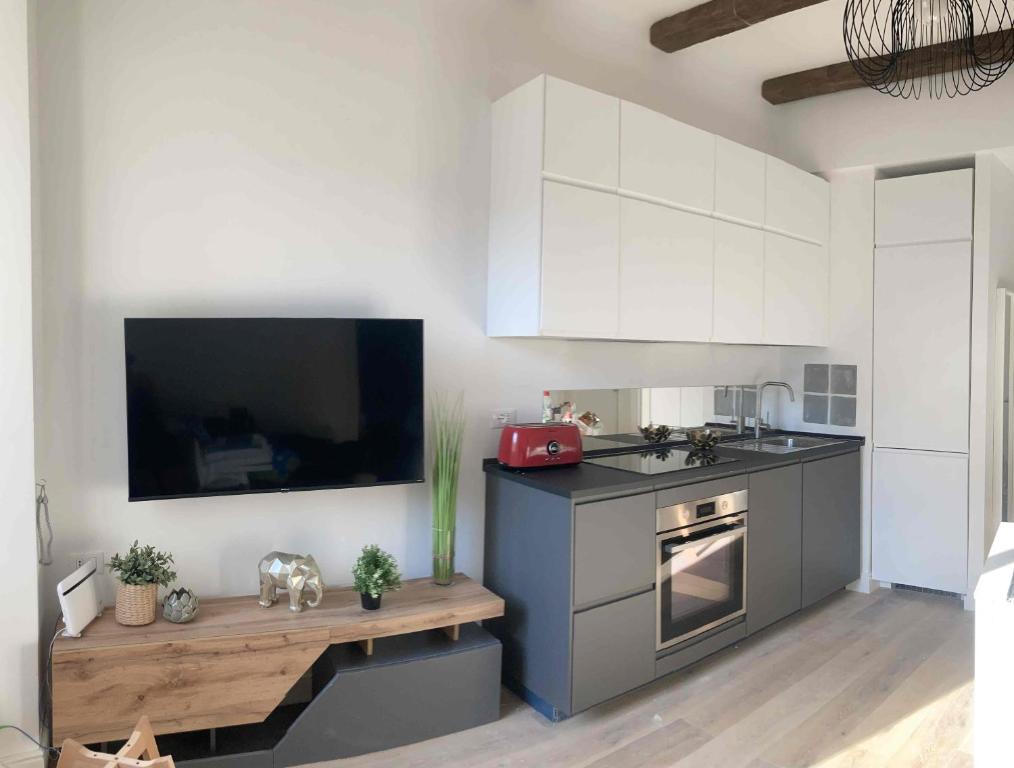 eine Küche mit einem Herd und einem TV an der Wand in der Unterkunft Happy Family Apartments Vigne in Genua