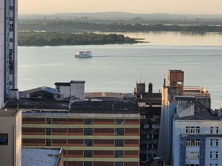 um barco na água em um rio com edifícios em De frente para o Guaíba. em Porto Alegre