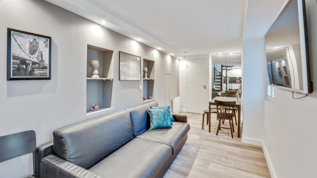 un salon avec un canapé et une salle à manger dans l'établissement 07 Tour Eiffel - Maison pour 5 personnes, à Paris