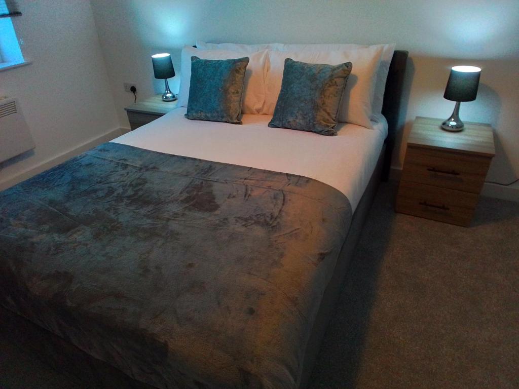 a bedroom with a large bed with two night stands at Apartment 13, Plants Yard in Worksop
