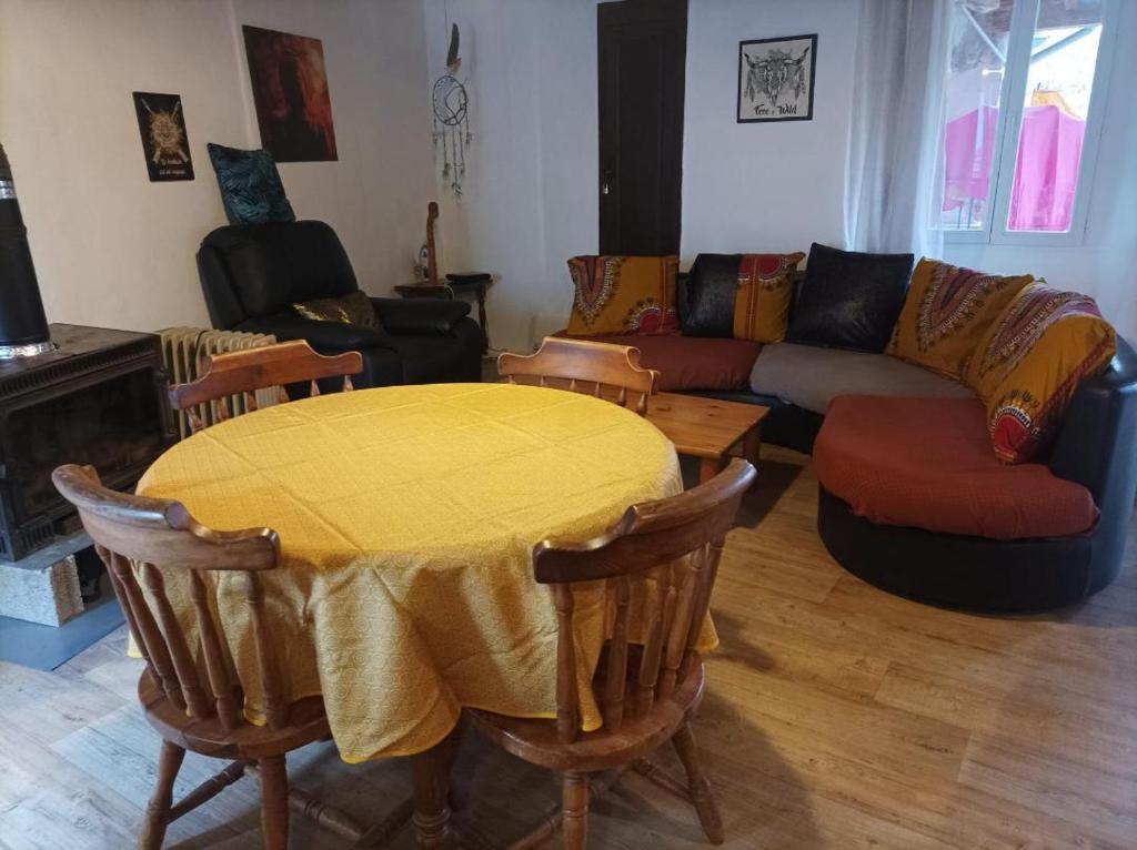 a living room with a yellow table and a couch at le Pountil in Valgorge
