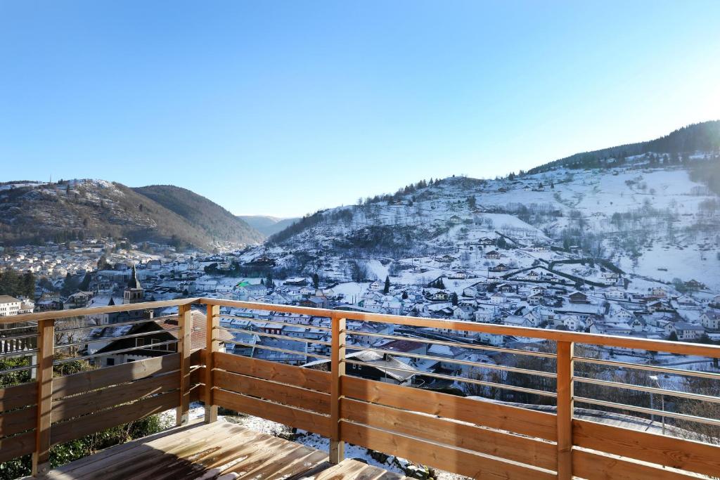 - une vue sur une ville enneigée depuis une clôture en bois dans l'établissement Duplex Fa7 - Duplex éco-rénové, à La Bresse