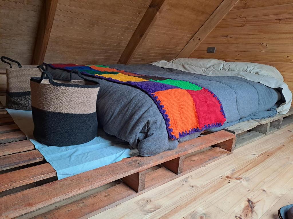 Una cama sobre una plataforma de madera en una habitación. en Refugio Golondrina, en Futrono