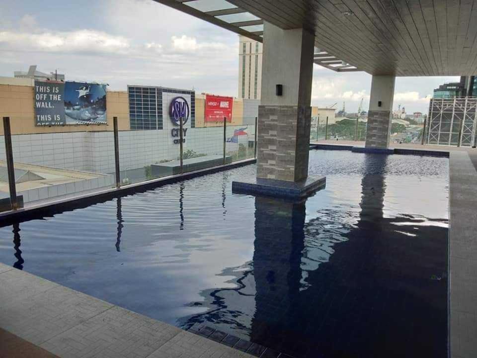 una piscina de agua frente a un edificio en Sarado do not book here please, en Cebú