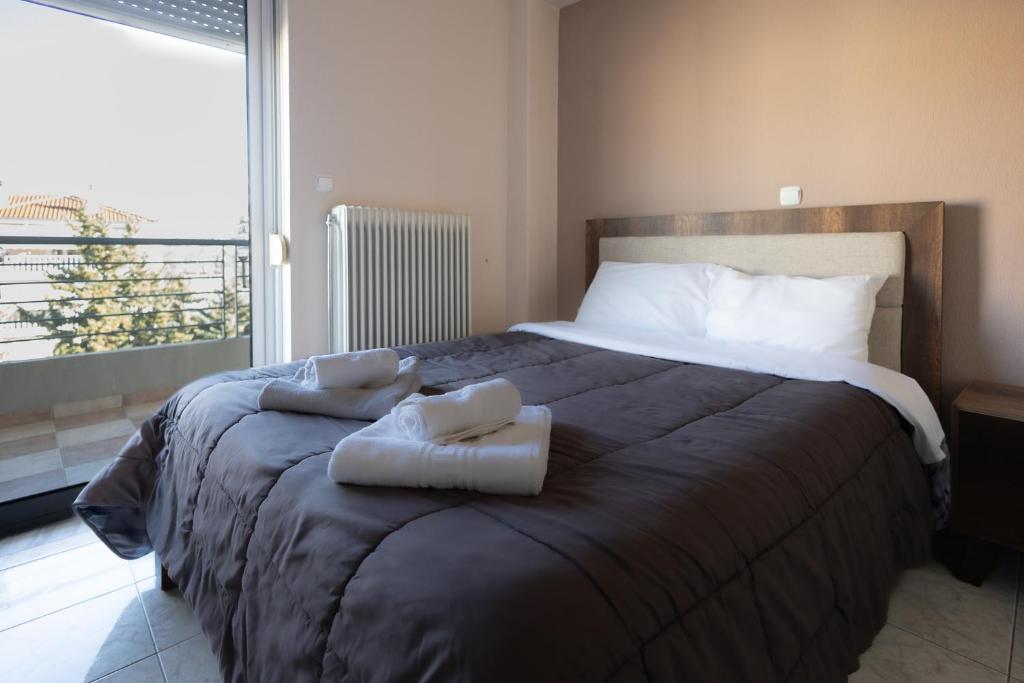 a bedroom with a large bed with two towels on it at Central apartment with parking in Larisa