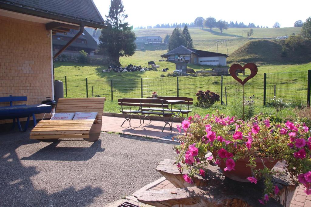 um jardim com um banco, uma mesa e flores em Sport Rees - Ferienwohnung Pia em Hofsgrund