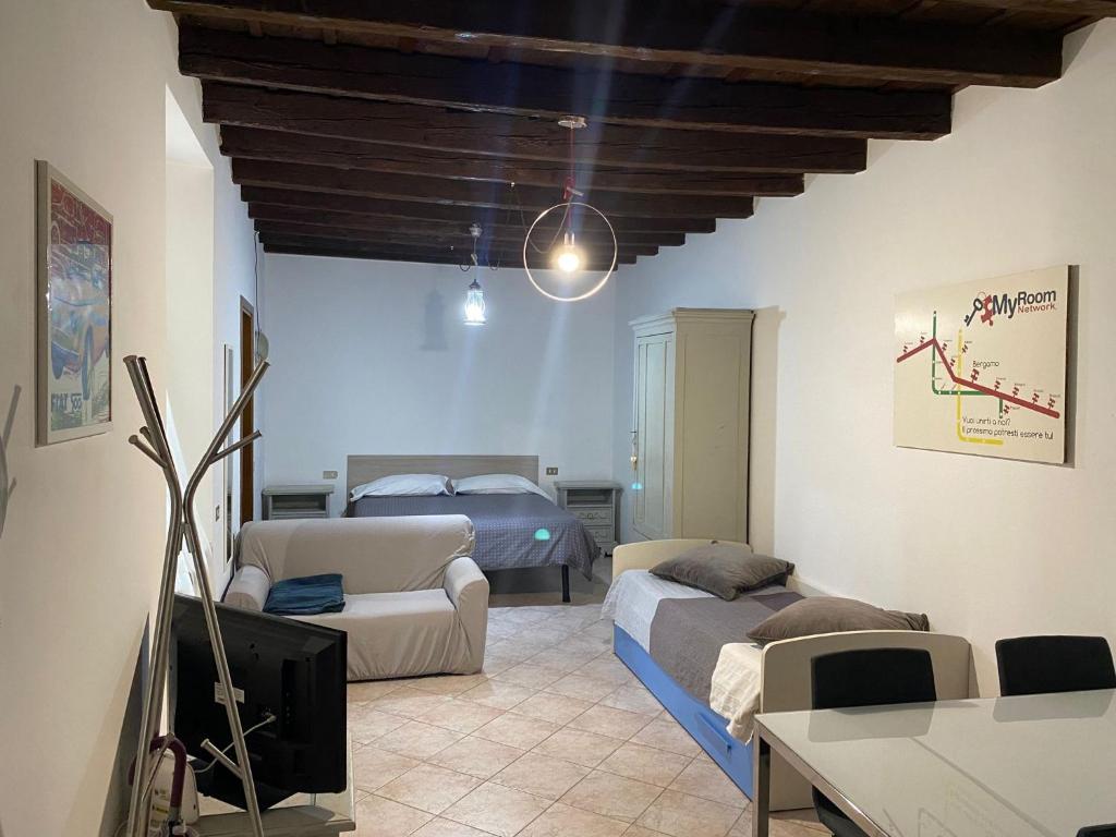 un soggiorno con letto e divano di MyRoom Center Flat a Bergamo