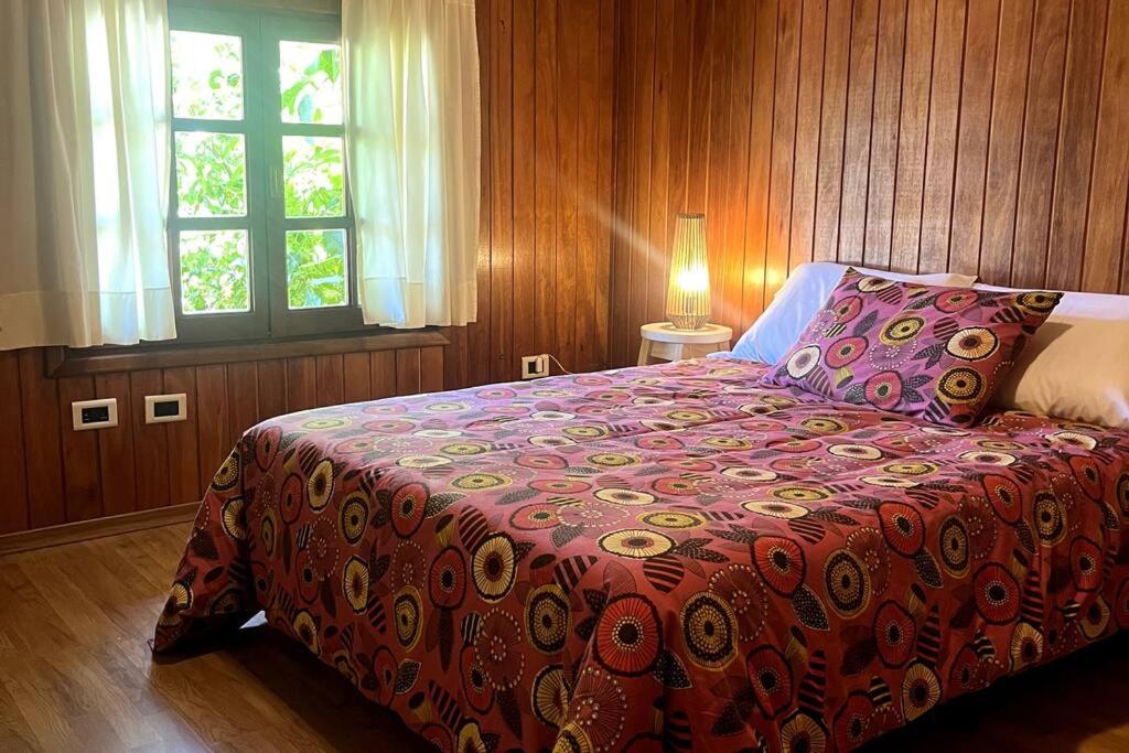 ein Schlafzimmer mit einem Bett mit einer roten Decke und einem Fenster in der Unterkunft Departamento Del Centro Primer Piso in El Bolsón