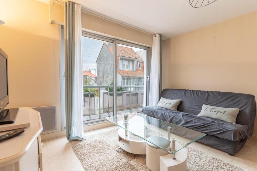 uma sala de estar com um sofá e uma grande janela em Pleasant 3-rooms apartment for 6 people with parking space em Le Touquet-Paris-Plage