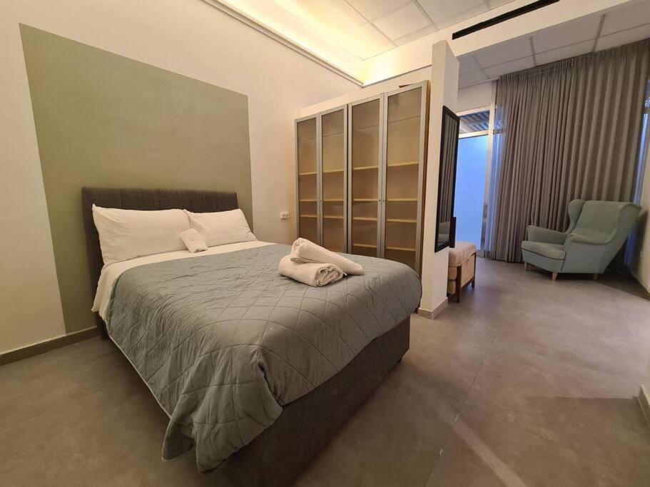 a bedroom with a bed and a chair in a room at White Elephant in Jerusalem
