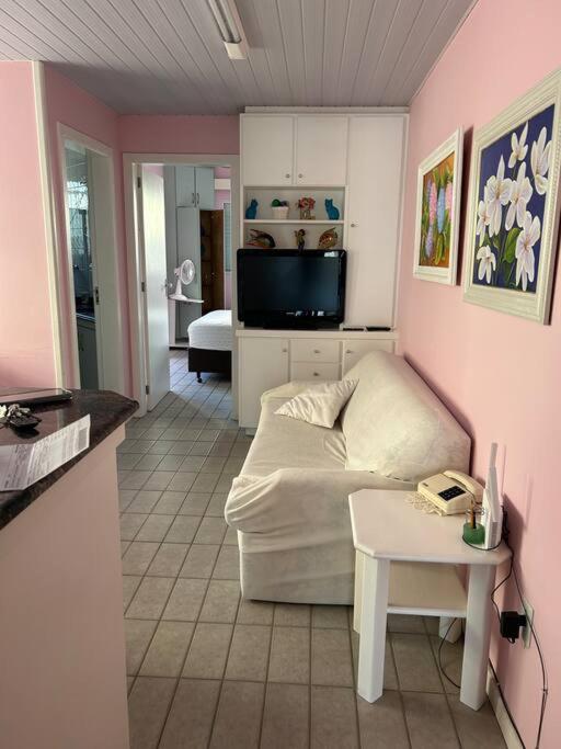 - un salon avec un canapé blanc et une table dans l'établissement Apartamento 100 mt da praia em Promoção, à Florianópolis