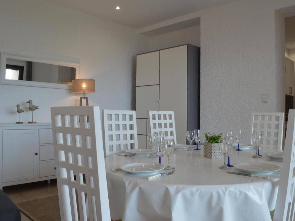 a dining room table with white chairs and a white table cloth at Appartement Banyuls-sur-Mer, 3 pièces, 5 personnes - FR-1-225C-39 in Banyuls-sur-Mer