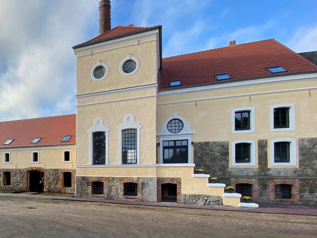 un bâtiment avec une tour d'horloge en haut dans l'établissement Brennerei Federow, à Federow