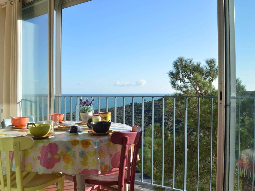 un tavolo e sedie su un balcone con vista sull'oceano di Appartement Banyuls-sur-Mer, 2 pièces, 4 personnes - FR-1-225C-4 a Banyuls-sur-Mer