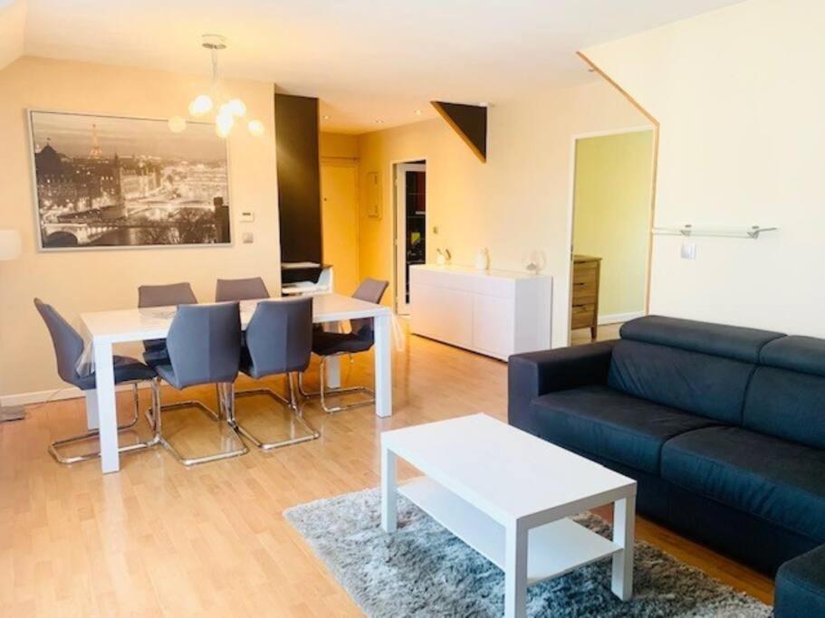 un salon avec un canapé et une table dans l'établissement Superbe appartement proche Disney, à Bussy-Saint-Georges