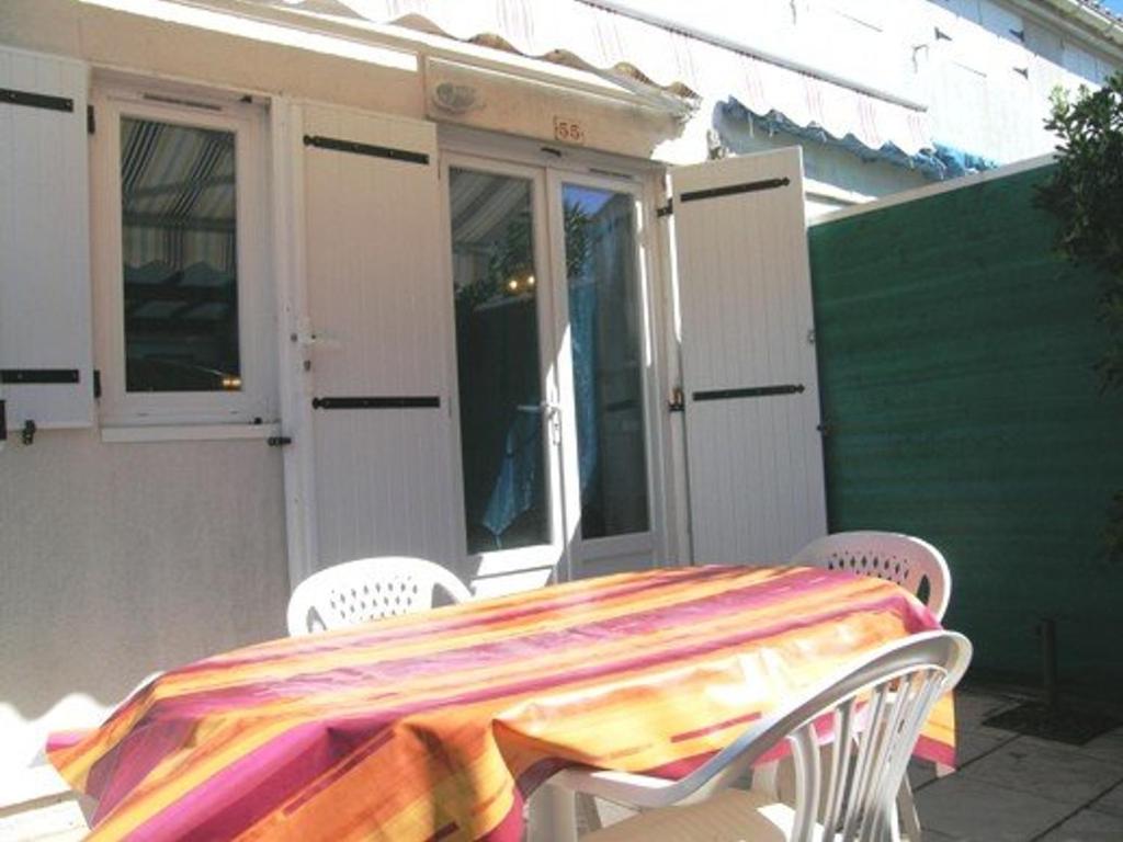 une table avec un tissu de table coloré sur une terrasse dans l'établissement Maison rénovée proche plage, quartier calme, parking privé, animaux acceptés - FR-1-387-108, à Marseillan