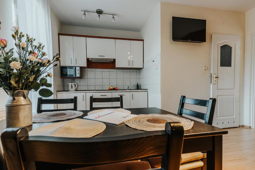 einen Esstisch mit Stühlen und eine Küche in der Unterkunft VisitZakopane - Apartament Halny in Zakopane