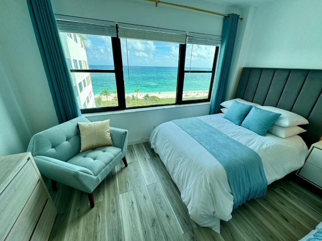 a bedroom with a bed and a chair and the ocean at Directly on the Beach with Pool & Ocean View in Miami Beach