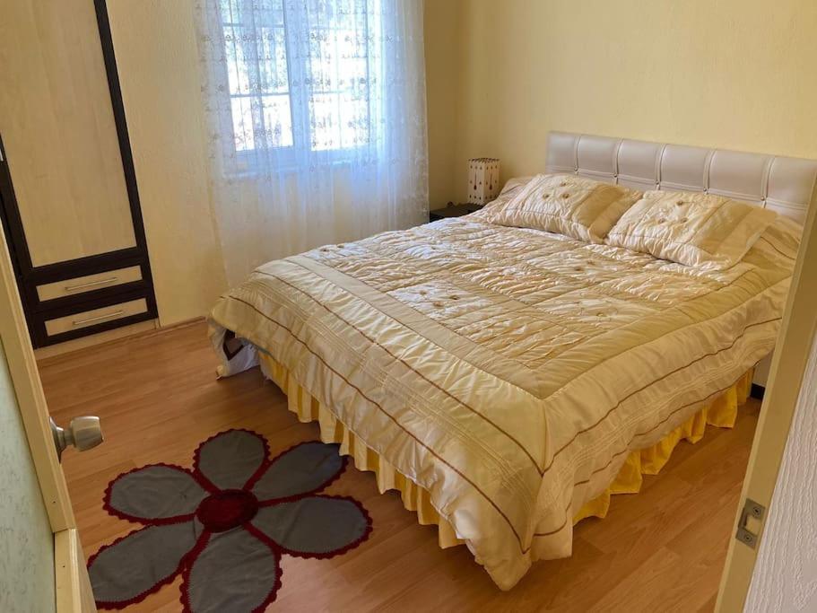 1 dormitorio con 1 cama con una flor en el suelo en ormanın içinde geniş havuzlu triplex villa, en Manavgat
