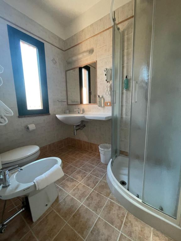 a bathroom with a shower and a toilet and a sink at Hotel Marco Polo in Lido di Jesolo