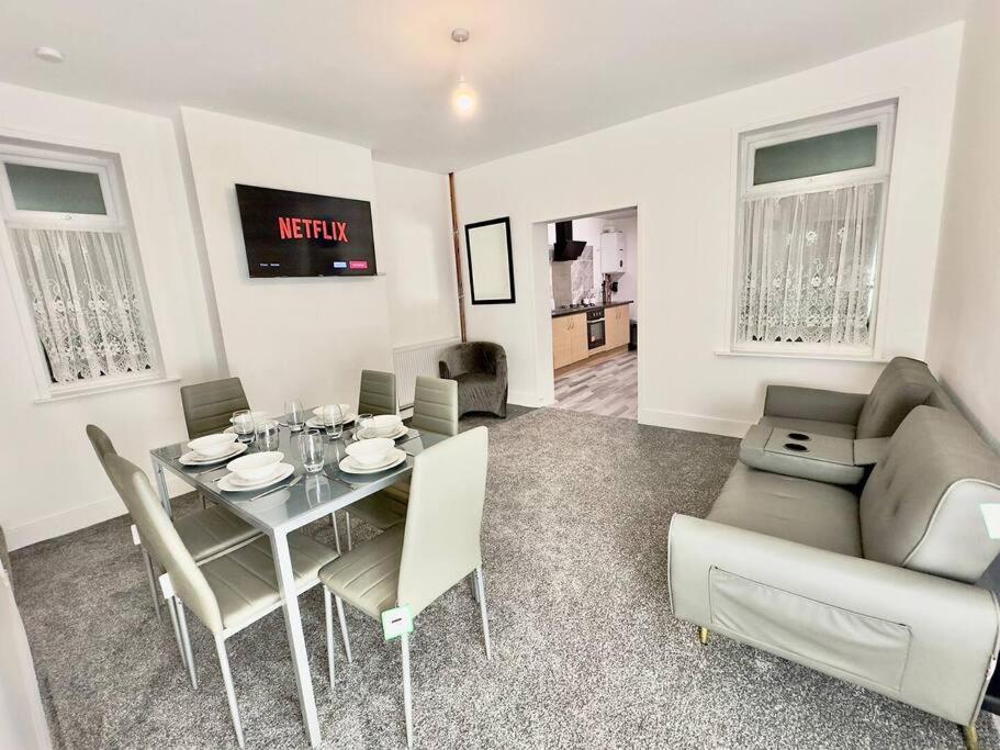 a living room with a table and a couch at Spacious Accommodation for Contractors and Families 4 Bedrooms, Sleeps 8, Smart TV, Netflix, Parking, Only 20 Minutes to Birmingham, M6 J9 in Darlaston