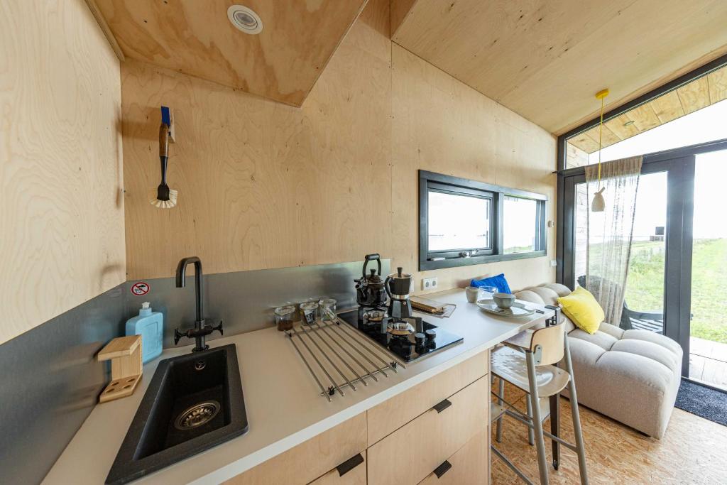 una cucina con lavandino e piano di lavoro di Slapen op de Dijk - Tiny House a Kraggenburg