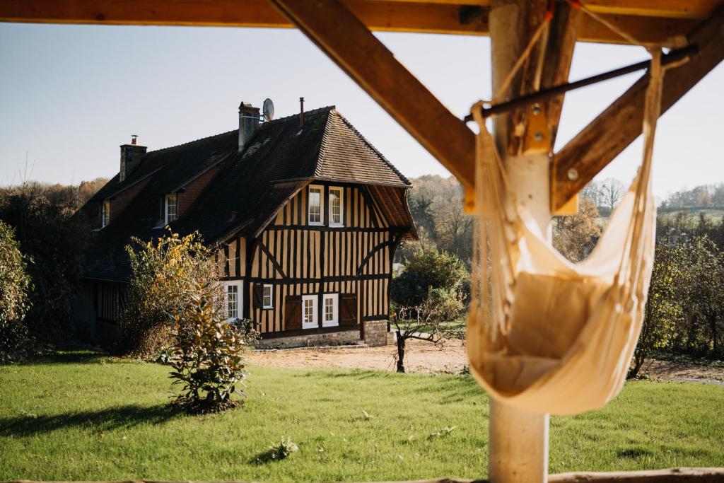 un columpio frente a una casa en Colombe - Une Maison du Pays d'Auge - Bain nordique, en Le Mesnil-Eudes