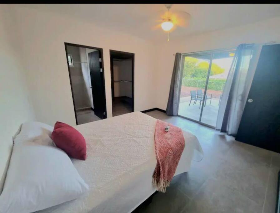 een slaapkamer met een groot wit bed met rode kussens bij Castillo de Aslan. Casa nueva cerca de Playa Grande in Huacas