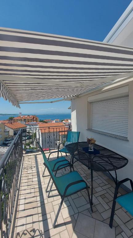 a patio with a table and chairs on a balcony at MT SUN 115 App 2 by Aneo Travel in Selce