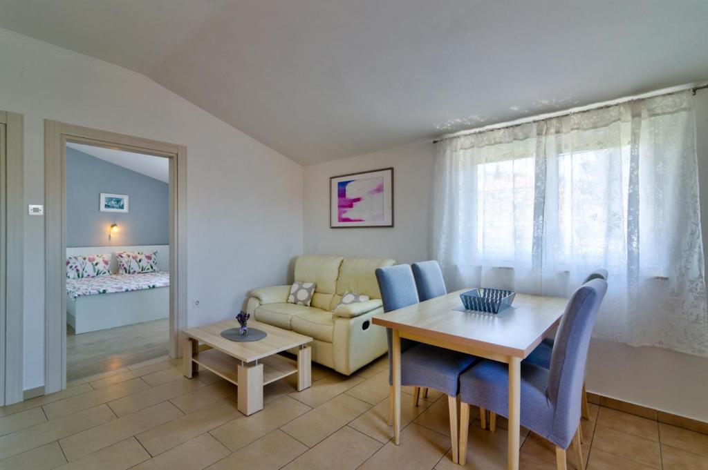 a living room with a table and chairs and a couch at MT SUN 115 App 2 in Selce