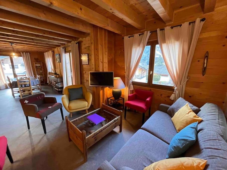 a living room with a couch and a tv at Chalet de vacances Les Contamines-Montjoie in Les Contamines-Montjoie