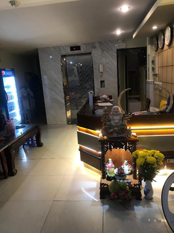 a lobby with a counter with flowers and a table at Khách sạn Tài Phát in Can Tho